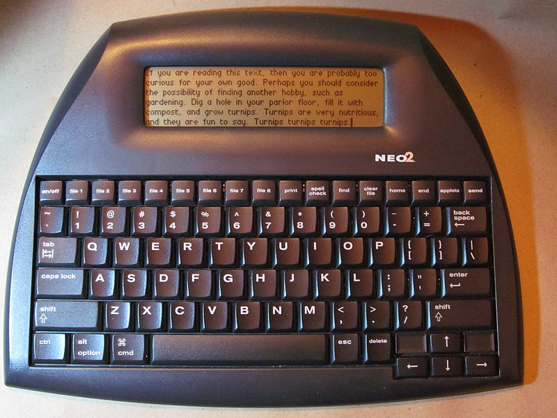 a curvey dark gray plastic bodied keyboard device with a taller LCD display
